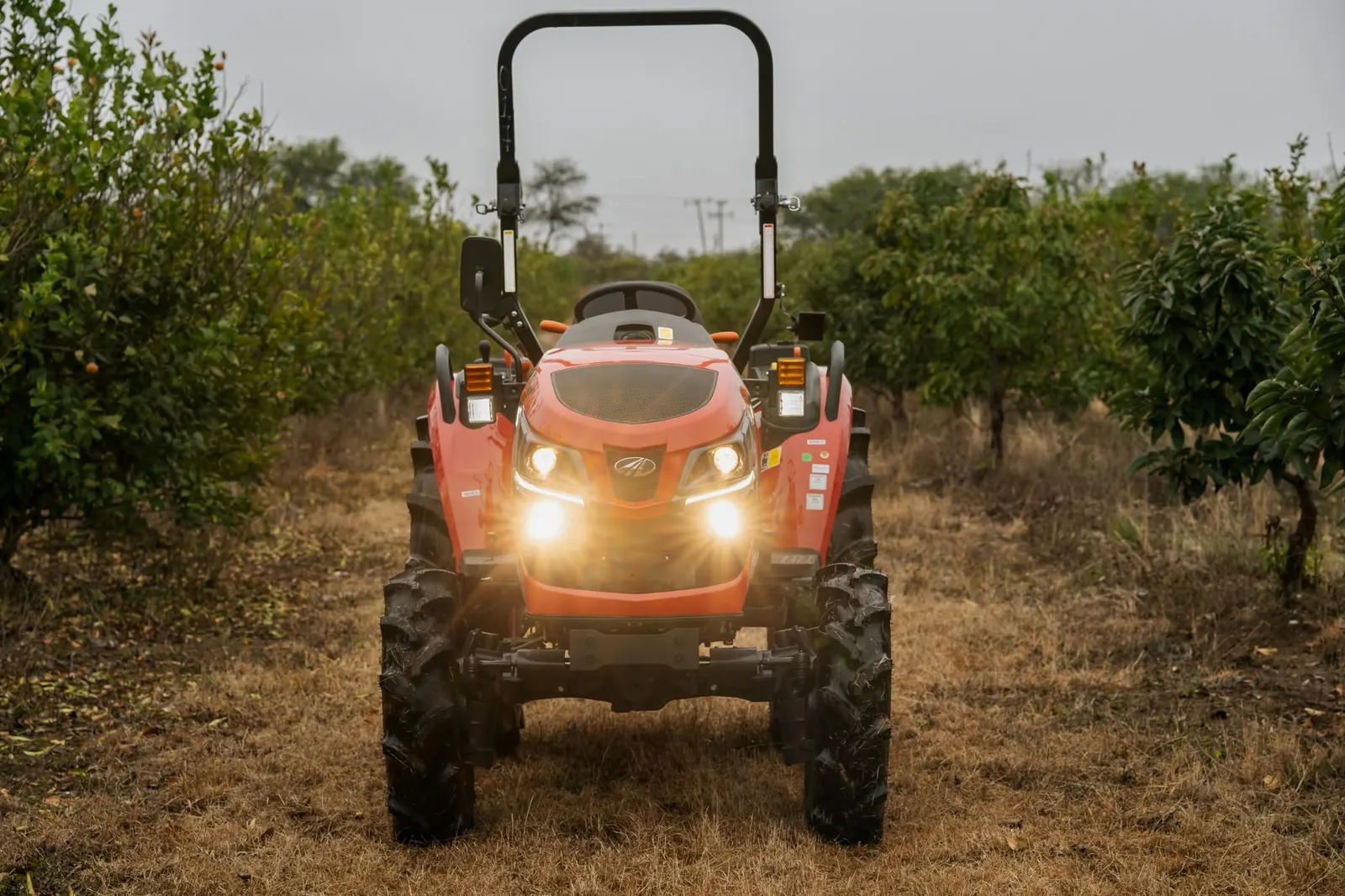 OJA 2130 con las luces encendidas entre árboles frutales
